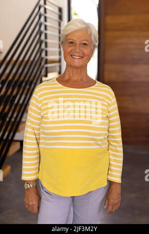 Porträt einer lächelnden älteren Frau mit kurzen Haaren, die im Pflegeheim steht Stockfoto