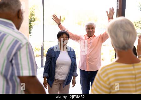 Biracial Senioren männlich und weiblich begrüßen fröhliche Freunde im Pflegeheim, kopieren Raum Stockfoto