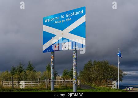 Willkommen bei Scotland Zeichen und Flagge, an der Grenze zwischen England und Schottland in Carter Bar in den Scottish Borders. Umgeben von Sturmwolken. VEREINIGTES KÖNIGREICH Stockfoto