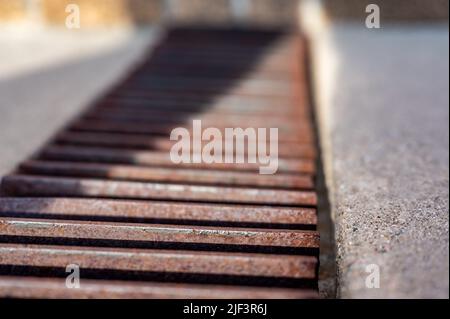 Rost über einem Regenwassergruben in einer Betonplatte. Stockfoto