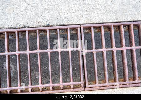 Rost über einem Regenwassergruben in einer Betonplatte. Stockfoto