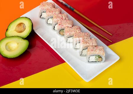 Nigiri Sushi Sets, Uramaki, Kalifornien, Philadelphia, auf einem weißen Teller. In der Nähe von Ingwer und Wasabi. Sojasauce in einer weißen Schüssel. Auf farbigem Hintergrund. Co Stockfoto