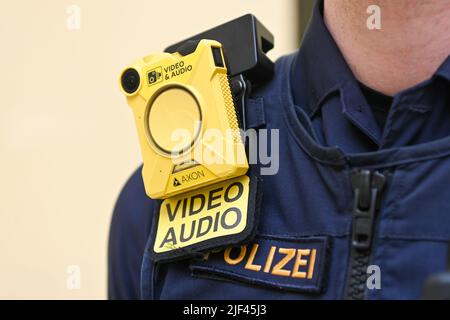 München, Deutschland. 29.. Juni 2022. Ein Polizeibeamter trägt eine Bodycam, die bei einer Pressekonferenz aufgenommen wurde. Das Bayerische Innenministerium legt den bayernweiten Lagebericht über Gewalt gegen Polizisten im Jahr 2021 vor. Quelle: Tobias Hase/dpa/Alamy Live News Stockfoto