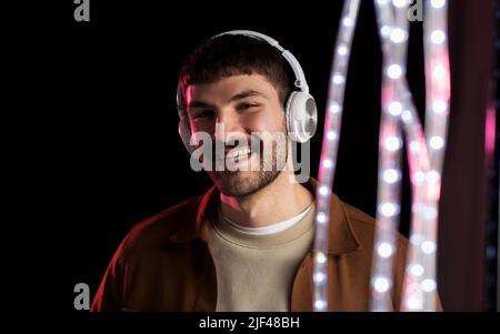 Mann in Kopfhörer über Neon Lichter der Nacht Club Stockfoto