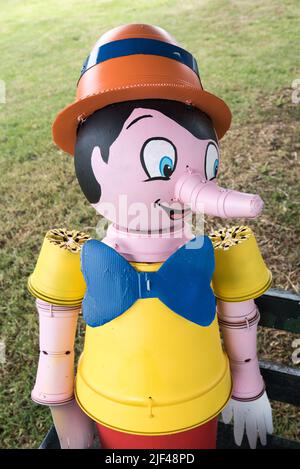 Settle Flowerpot Festival 2022 findet im Juli und August statt, dies muss Pinocchio sein, der auf einer Bank in Upper Settle sitzt. Stockfoto