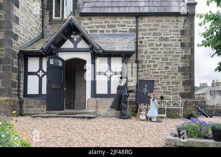 Das Settle Flowerpot Festival 2022 findet im Juli und August statt. Dieser Lehrer, Schüler und Tafel befindet sich außerhalb der Alten Schule in Upper Settle. Stockfoto