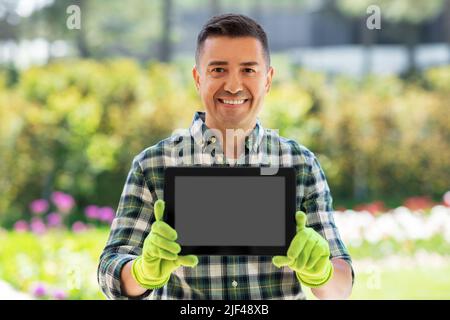 Glücklicher Mann mit Tablet-pc im Sommergarten Stockfoto