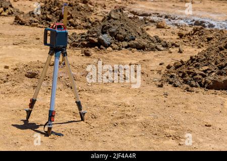 Während eines Baugrabens für ein Betonfundament verwendet der Auftragnehmer rotative Laser-Nivelliergeräte Stockfoto