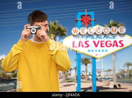 Mann mit Vintage-Filmkamera über Las vegas-Schild Stockfoto