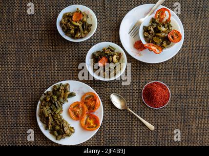 Bhindi Masala,Bharwa Bhindi do Pyaza wird in Butter und Gewürzen sautierte Okra gewürfelt.serviert mit Naan und gegrillten Tomaten in Indien und Pakistan.Nahaufnahme. Stockfoto