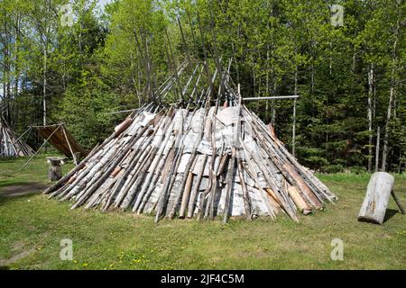 Eine Nachbildung eines Ojibwa-, Ojibwe- oder Anishinaabe-Wigwams aus Birkenrinde in ovaler Form, der am Grand Portage National Monument im Norden von Minnesota, USA, wohnt Stockfoto