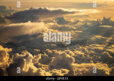 Strahlen der Sonne, die bei Sonnenuntergang durch die Wolken ziehen. Luftaufnahme des Sonnenuntergangs. Umgebungskonzept Stockfoto