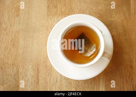 Grüner Tee mit Teebeutel auf Fliesen Hintergrund Stockfoto