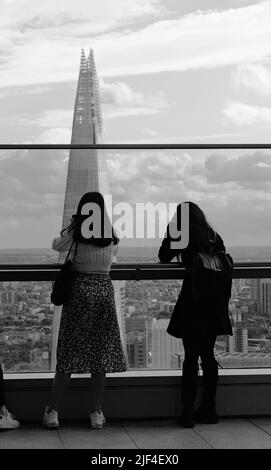 Zwei Weibliche Touristen, Die Von Der Aussichtsplattform Im Skygarden In Der 20 Fenchurch Street, London, Bilder Von The Shard Und Der Skyline Von London Machen Stockfoto