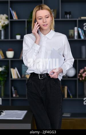 Frau telefoniert im Büro. Stockfoto