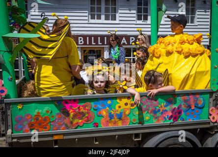 Kinder in gelben Kostümen sitzen auf einem Festwagen während der Billingshurst Show in West Sussex, Großbritannien. Stockfoto