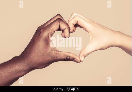 Menschen verschiedenen Hautfarben setzen ihre Hände zusammen, so dass Herz in weißen Hintergrund. Nächstenliebe, Liebe und Vielfalt - Nahaufnahme von Frau und Mann Stockfoto