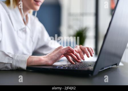 Frauenhand beim Tippen auf der Tastatur. Stockfoto