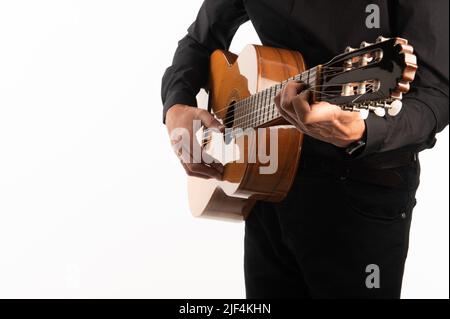 Isolierte klassische Gitarre und die Hände des Gitarristen aus nächster Nähe auf weißem Hintergrund. Stockfoto