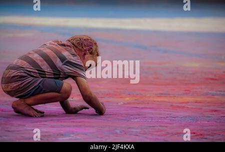 Manresa, Spanien, 24. August 2012: Kind malt den Boden in einer Gruppe von Farben. Stockfoto