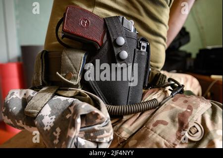 Pistole und Holster im Militärgürtel, persönlicher Schutz, Militär in militärischer Pixeluniform. Ukrainische 9mm Pistole PM Makarov. Stockfoto