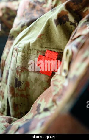 Chevrons auf dem ukrainischen Militär-Pixel-Uniform, rotes Kreuz-Zeichen. Stockfoto