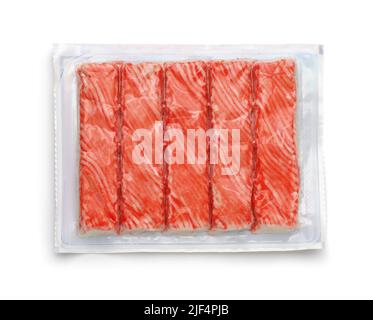 Draufsicht auf gekühlte Krabbenstäbchen in klarer Kunststoffverpackung isoliert auf Weiß Stockfoto