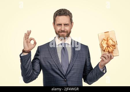 Geschäftsmann zeigt Geschenkbox. Firmengeschenk. Frauentag. Erfolgreicher ceo halten geschenkbox. ok. Stockfoto