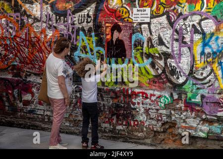 Moskau, Russland. 28.. Juni 2022. Ein kleiner Fan des Sängers macht ein Foto von Viktor Tsois Mauer in der Arbat-Straße im Zentrum von Moskau, Russland Stockfoto