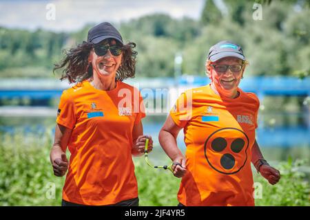 Sehbewehrte Joggerin mit ihrer weiblichen Laufguide. In einigen werden Laufguides for bilinde and sehbeeintraechtigte Laeuferinnen ausgestellt Stockfoto