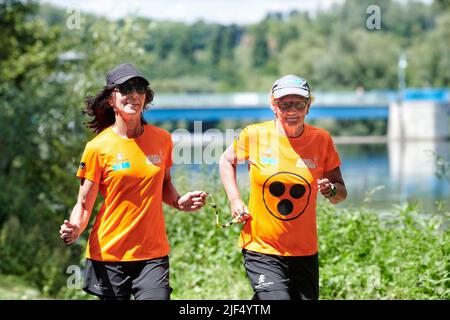 Sehbewehrte Joggerin mit ihrer weiblichen Laufguide. In einigen werden Laufguides for bilinde and sehbeeintraechtigte Laeuferinnen ausgestellt Stockfoto