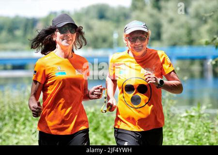 Sehbewehrte Joggerin mit ihrer weiblichen Laufguide. In einigen werden Laufguides for bilinde and sehbeeintraechtigte Laeuferinnen ausgestellt Stockfoto