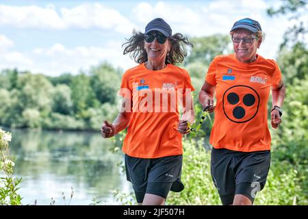 Sehbewehrte Joggerin mit ihrer weiblichen Laufguide. In einigen werden Laufguides for bilinde and sehbeeintraechtigte Laeuferinnen ausgestellt Stockfoto