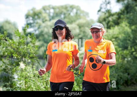 Sehbewehrte Joggerin mit ihrer weiblichen Laufguide. In einigen werden Laufguides for bilinde and sehbeeintraechtigte Laeuferinnen ausgestellt Stockfoto