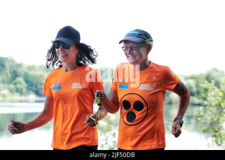 Sehbewehrte Joggerin mit ihrer weiblichen Laufguide. In einigen werden Laufguides for bilinde and sehbeeintraechtigte Laeuferinnen ausgestellt Stockfoto