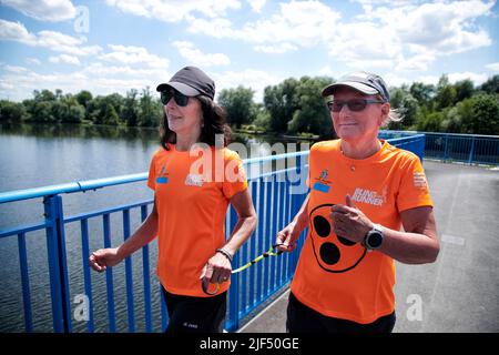 Sehbewehrte Joggerin mit ihrer weiblichen Laufguide. In einigen werden Laufguides for bilinde and sehbeeintraechtigte Laeuferinnen ausgestellt Stockfoto