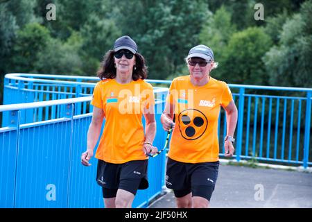 Sehbewehrte Joggerin mit ihrer weiblichen Laufguide. In einigen werden Laufguides for bilinde and sehbeeintraechtigte Laeuferinnen ausgestellt Stockfoto