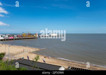 Clacton Pier, der sich in die Nordsee vor Clacton on on Sea, Essex, Großbritannien, erstreckt. Gunfleet Sands Offshore-Windpark am Horizont Stockfoto