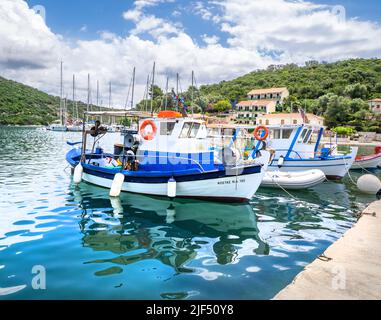 Boote, die am Wasser im hübschen geschützten Hafen von Sivota auf der Insel Lefkada auf den ionischen Inseln Griechenlands festgemacht werden Stockfoto