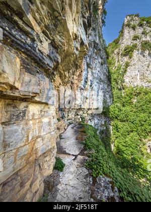 Enger, prekärer Pfad, der in die schiere Felswand hinter dem Kloster Agia Paraskevi hoch über der Vikos-Schlucht in der Region Zagori in Griechenland eingehauen ist Stockfoto