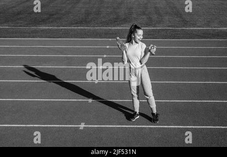 Teen Mädchen Training mit Hanteln und Wasserflasche auf Outdoor-Stadion, Fitness Stockfoto