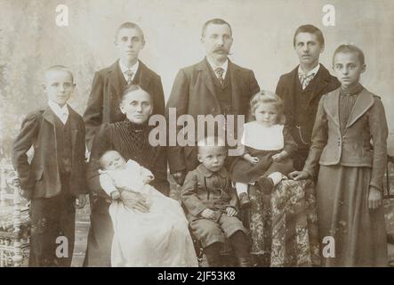 Antike Fotografie einer siebenköpfigen Familie aus dem Jahr 1870 in Basel, Schweiz. Die Eltern mittleren Alters haben Kinder im Alter von etwa 1 bis 17 Jahren. QUELLE: ORIGINALE FOTOKARTE Stockfoto