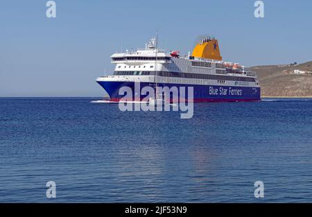 Blue Star, die Patmos Fähre, manövriert um ein kleines Segelboot, als sie zum Hafen von Livadia, Tilos Insel, in der Nähe von Rhodos anlegt. Mai 2022 Stockfoto