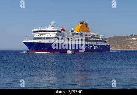 Blue Star, die Patmos Fähre, manövriert um ein kleines Segelboot, als sie zum Hafen von Livadia, Tilos Insel, in der Nähe von Rhodos anlegt. Mai 2022 Stockfoto