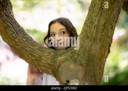 Porträt eines Porträts einer jungen Frau, die in einem japanischen Garten steht Stockfoto