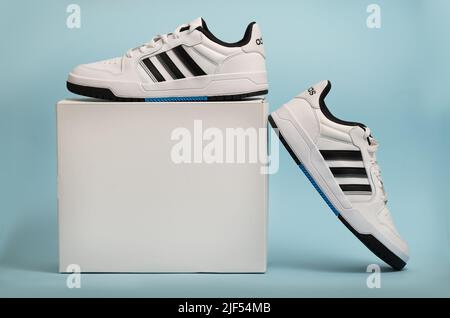 Belgrad, Serbien - 11. Mai 2022. Neue Adidas Tennisschuhe auf weißem Hintergrund mit Verpackungsbox. Neue Adidas Sneakers oder Sportschuhe auf blauem Hintergrund. Männer Stockfoto