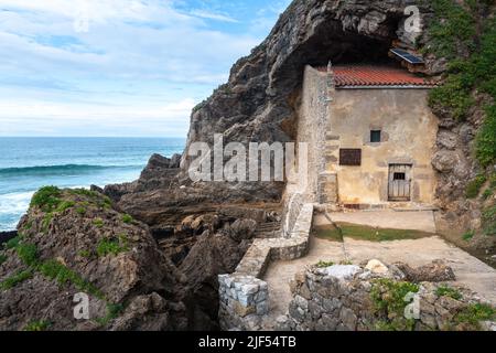 Die Eremitage von Santa Justa ist in den Felsen einer Klippe über dem Kantabrischen Meer, der Stadt Ubiarco in Kantabrien, Spanien, gehauen Stockfoto