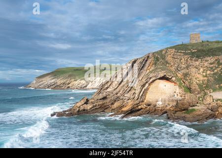 Die Eremitage von Santa Justa ist in den Felsen einer Klippe über dem Kantabrischen Meer, der Stadt Ubiarco in Kantabrien, Spanien, gehauen Stockfoto