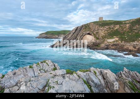 Die Eremitage von Santa Justa ist in den Felsen einer Klippe über dem Kantabrischen Meer, der Stadt Ubiarco in Kantabrien, Spanien, gehauen Stockfoto