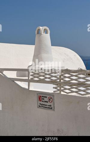 Oia, Santorini, Griechenland - 2022. Juni: Warnhinweis an der Wand eines Gebäudes warnt Besucher, dass keine Drohnen über die Stadt Oia fliegen dürfen Stockfoto